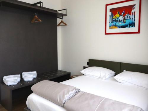 a bedroom with two beds and a picture on the wall at In einer klimatisierten Wohnung mit Terrasse in Marone