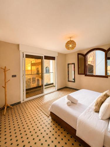 a bedroom with a large bed and a large window at Kymata Surf Morocco in Agadir