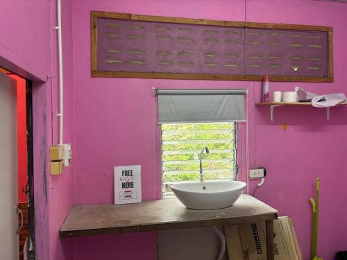 a bathroom with a sink and a pink wall at Pink Hostel in Ko Tao