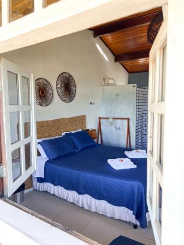 a bedroom with a bed with blue sheets at Pousada Ventoria in Canguaretama