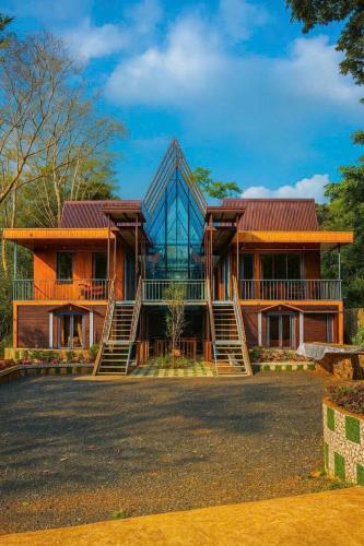 a house with a glass facade and stairs at Resort Đồi Thông in Kon Von Kla