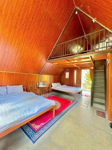 a bedroom with two beds and a loft at Resort Đồi Thông in Kon Von Kla