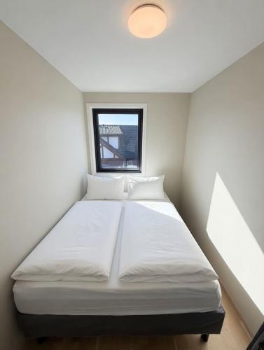a white bed in a room with a window at Rekkehus i Sandnes in Stavanger