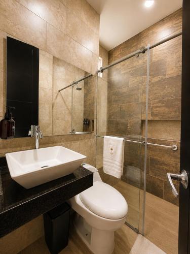 a bathroom with a sink and a toilet and a shower at Palmará Hotel in Villeta