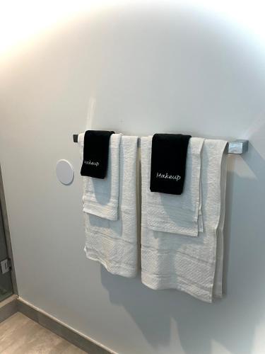 three towels hanging on a towel rack in a bathroom at Modern Downtown Miami Studio with Skyline View in Miami