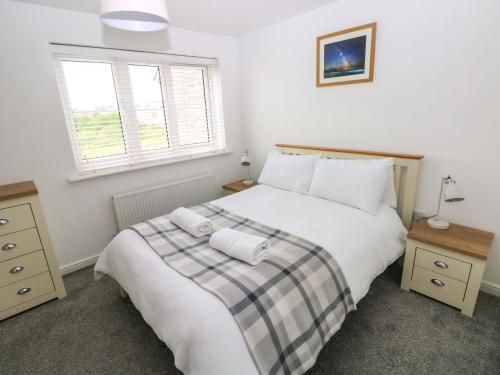 a bedroom with a large white bed with two pillows at 69 Ffordd Y Meillion in Llanelli