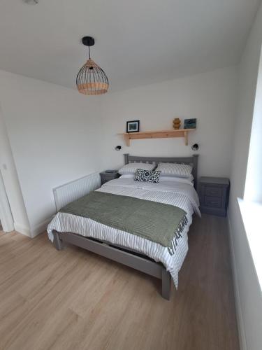 a bedroom with a bed and a chandelier at Tigh Droum in Rosscarbery