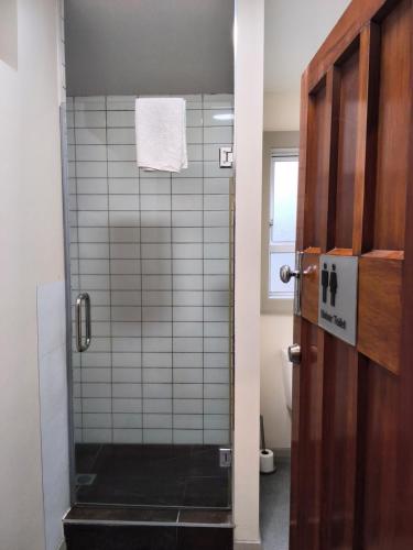 a bathroom with a shower with a glass door at North Beach Lodge in Christchurch