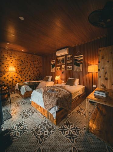 a bedroom with two beds and a table at Tam Cốc FAIRY WINGS Homestay in Vũ Lâm