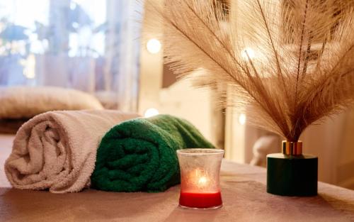 a table with a towel and a candle and a glass at Hotel Xbalamqué Boutique & Spa in Cancún