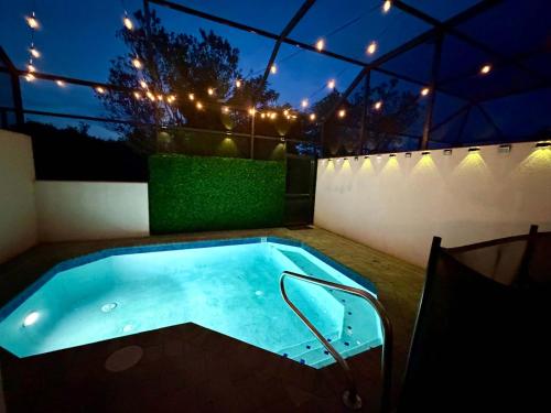 a hot tub in a backyard at night with lights at 5BR Getaway with Pool Arcade Games and Resort Access in Davenport