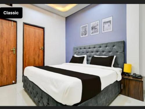 a bedroom with a large bed with a blue wall at Kanakplace in Indore