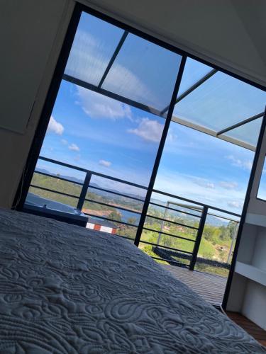 a bedroom with a large window with a view of the ocean at Cabaña XAMAI in La Pradera