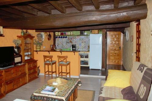 Una sala de estar con un sofá y una cocina. en Casa Angel, en Sequeros