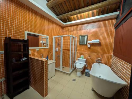 a bathroom with a tub and a toilet and a sink at PianoPiano B&B in Jincheng