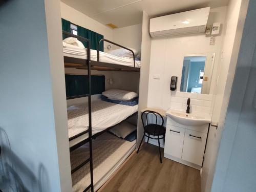 a small room with bunk beds and a sink at Highlander Van Village in Armidale