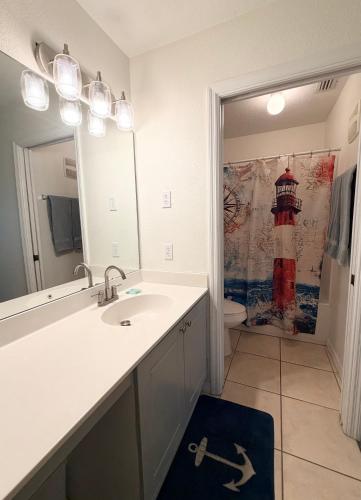 a bathroom with a sink and a mirror at Disney Kissimmee Condo in Kissimmee