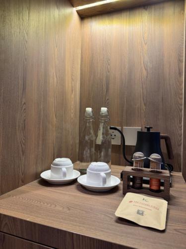 a wooden table with two cups and plates on it at Kaiarasa Villas and Suite in Canggu