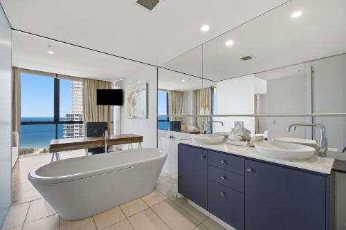 a bathroom with two sinks and a tub and a large mirror at Aria Apartments in Gold Coast