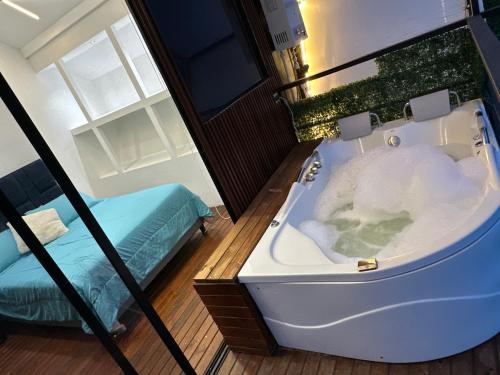 a bath tub in a room with a bed at Cabaña XAMAI in La Pradera