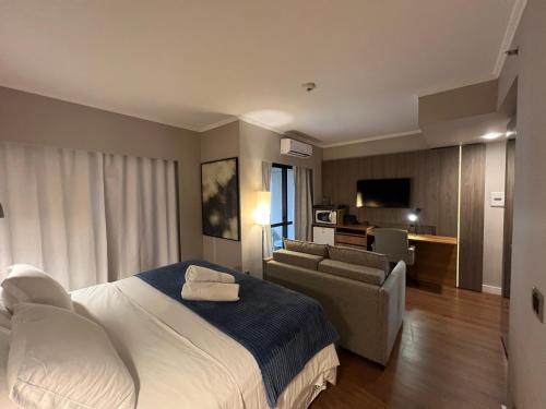 a hotel room with a bed and a couch at Apart Hotel Itaim Bibi in São Paulo