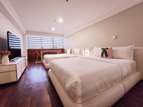 a hotel room with two beds and a couch at Glocaloca gwanghwamun in Seoul