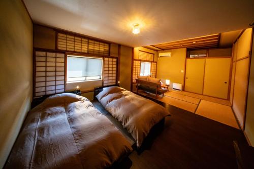 a bedroom with two beds and a window at AIBIYA in Yamanouchi