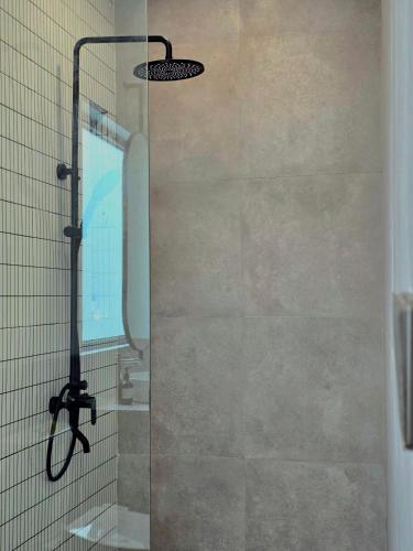 a shower with a glass door in a bathroom at Sekar Uluwatu in Uluwatu