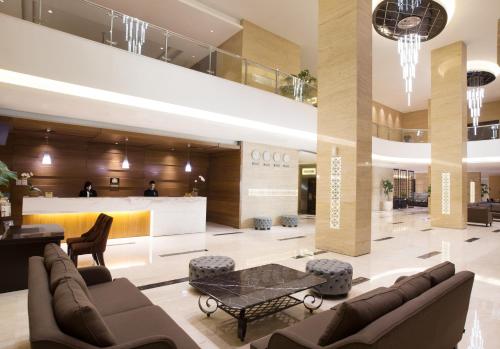 a lobby with couches and a table in a building at Grand Mercure Solo Baru in Solo