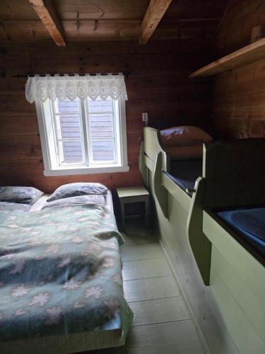 a bedroom with two beds and a window at Hardanger Kulturgalleri in Herand