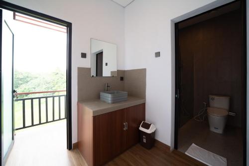 a bathroom with a sink and a mirror at Lunaire Guest House in Tabanan