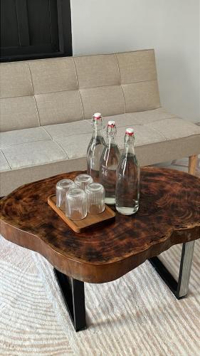 a wooden coffee table with four glass bottles on it at Nồm House in Nha Trang