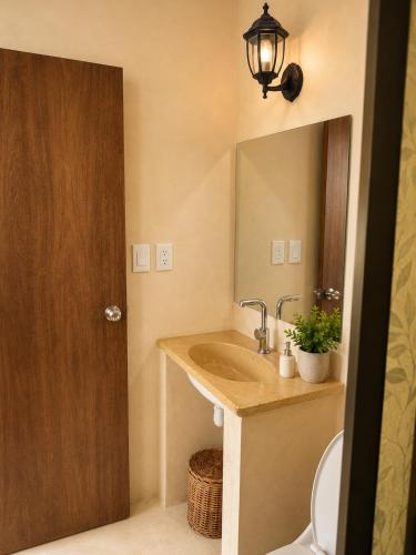 a bathroom with a sink and a mirror at Puul Suites in Mérida