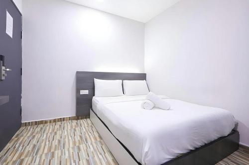 a bedroom with a large white bed with white pillows at Fast Hotel Idaman Near To IIUM KL in Kuala Lumpur