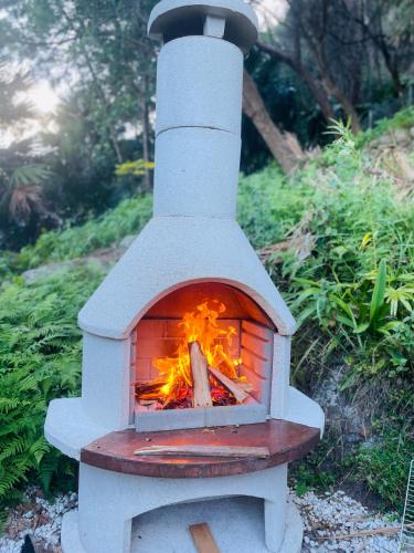 a brick oven with a fire inside of it at Mackerel Beach Wellness Lodge in Great Mackerel Beach