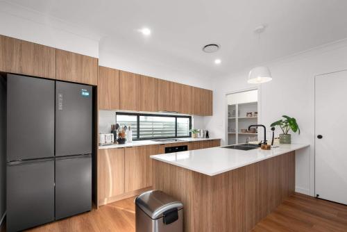 a kitchen with a black refrigerator and wooden cabinets at Stylish Clontarf Townhouse & Parking in Clontarf