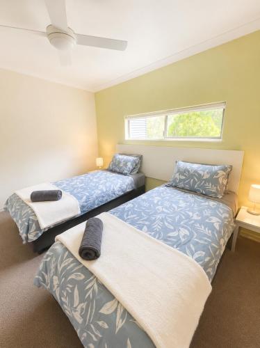 a bedroom with two beds and a window at Townhouse 7 - Located at FOOTPRINTS PRESTON BEACH RESORT in Preston Beach