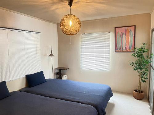 a bedroom with a blue bed and a potted plant at 江の島HOUSE Comfortable & Relaxing Stay in Fujisawa