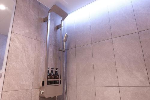 a glass shower door with bottles of wine in a bathroom at Seocho JS Hotel in Seoul