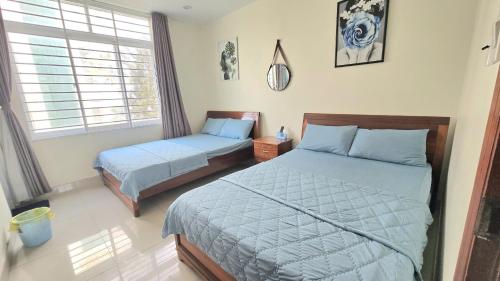 a bedroom with two beds and a window at Chu's Hotel & Homestay in Xã Thang Tam