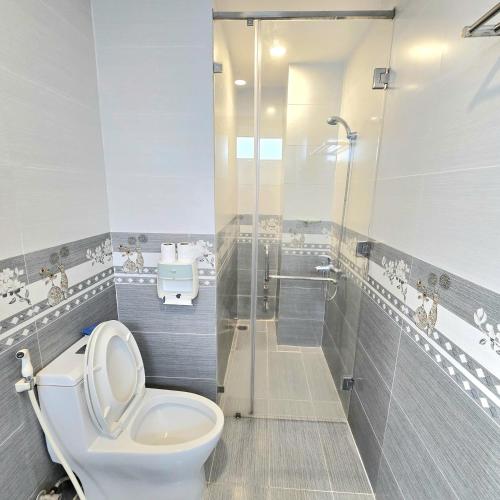 a bathroom with a toilet and a shower at Chu's Hotel & Homestay in Xã Thang Tam