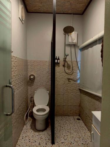 a bathroom with a toilet and a shower at Baan Sahai Tone บ้านสหายโทน in Ko Larn