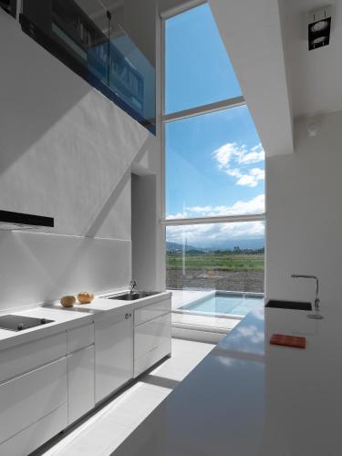 una cucina con mobili bianchi e una grande finestra di Water House a Città di Yilan
