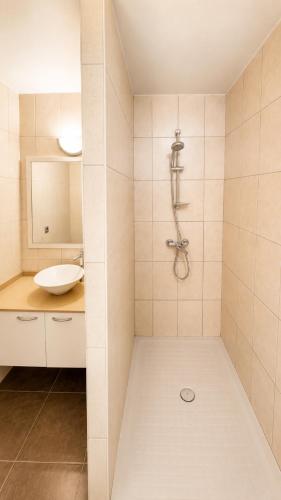 a white bathroom with a sink and a shower at Blue Lagoon - Studio avec accès piscine in Papeete