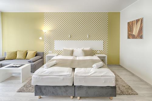 - une chambre avec un grand lit et un canapé dans l'établissement Apartment Promenáda 35, à Karlovy Vary