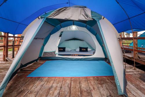a blue and white tent with a wooden floor at WWS Cabin By ARBA in Palayangan