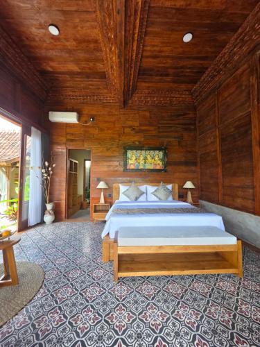 a bedroom with a bed and a wooden ceiling at Pondok Kumpi ubud in Ubud