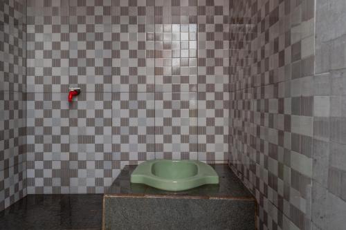 a bathroom with a green urinal on a tiled wall at WWS Cabin By ARBA in Palayangan