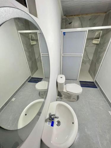 a bathroom with two toilets and a sink and a mirror at Limsor Town Apartaestudios in San Andrés