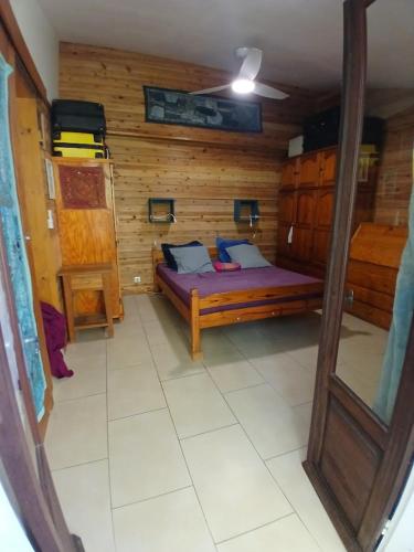 a bedroom with a bed in a wooden room at maison entière in Saint-Pierre